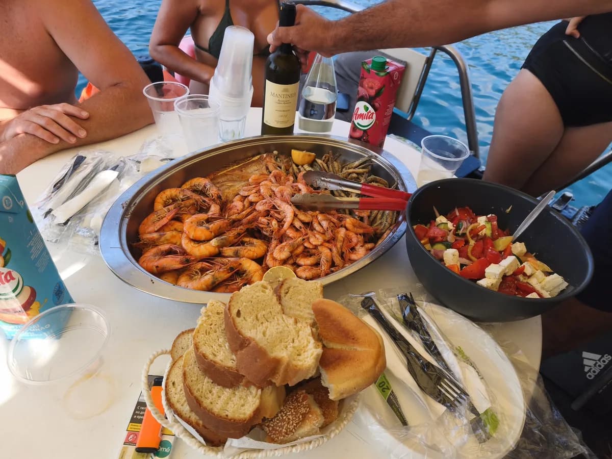 A platter of grilled prawns, fried fish and Greek salad served on the boat