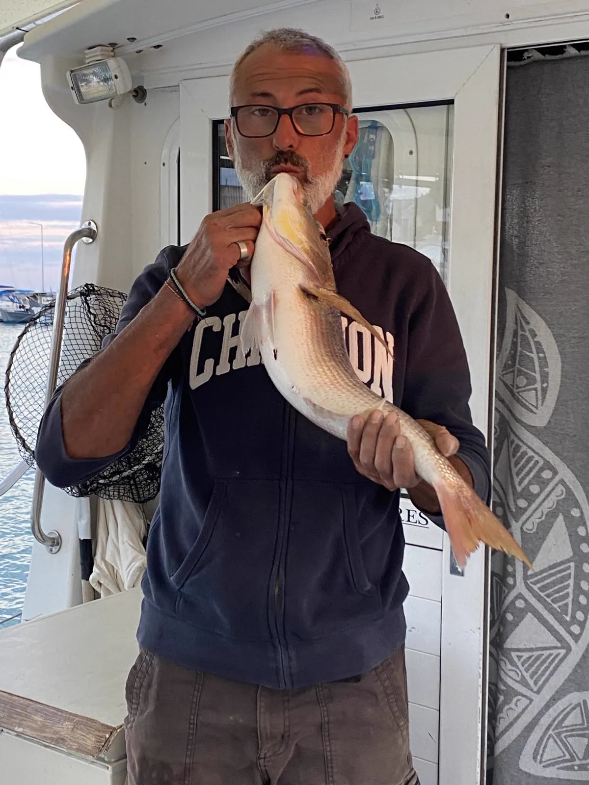 Dimitris holding a large fish aboard the Fishing 4 You boat