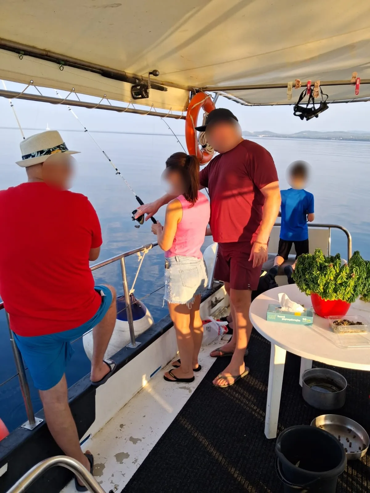 A family fishing from the rail at sunset, faces privacy-protected