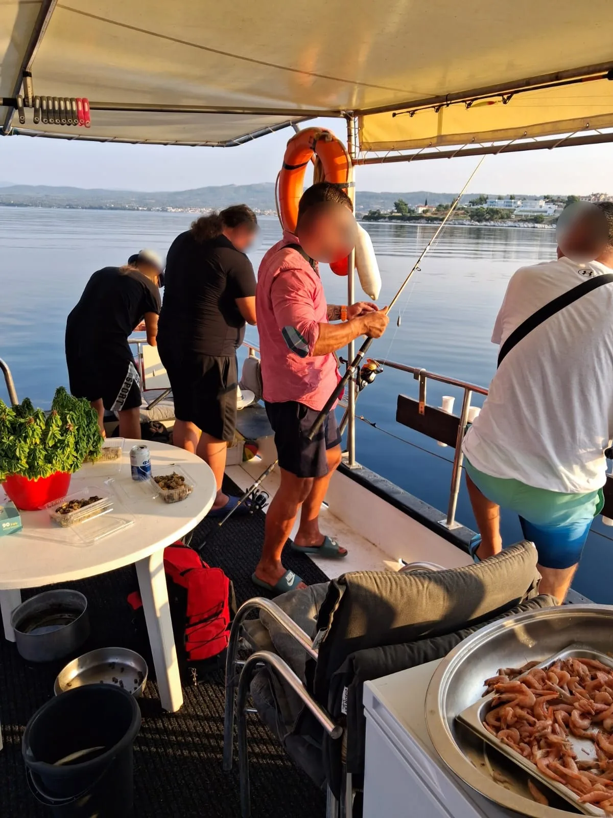 Guests fishing in the evening light with the coast behind, faces privacy-protected