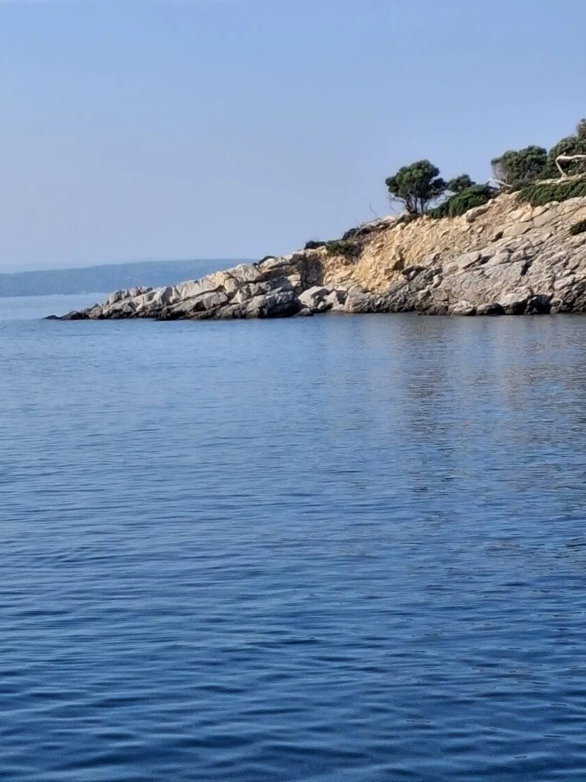 The rocky coastline of Kelyfos island seen from the water