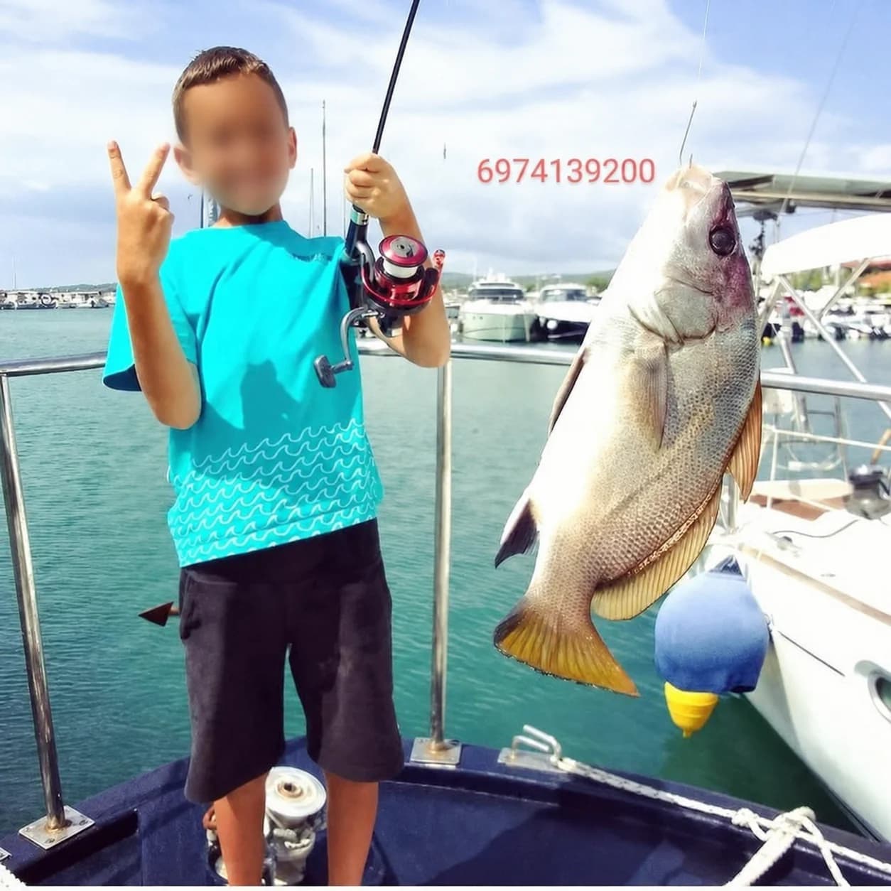 A young guest with a large fish and face privacy-protected